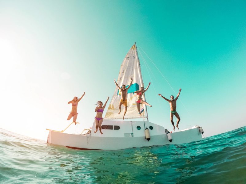 amis plongeant du bateau à voile dans la mer concept location bateau entre particuliers